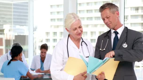 Two doctors with their colleagues behind — Stock Video