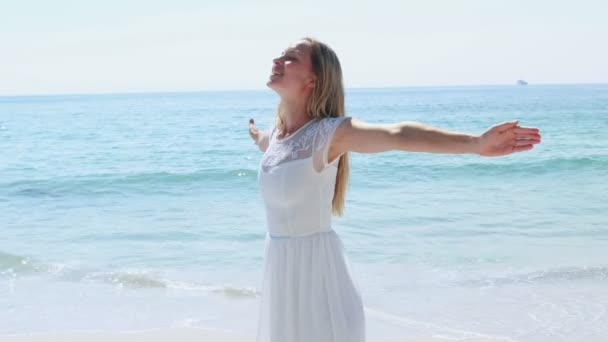 Mujer rubia con los brazos extendidos en la playa — Vídeo de stock