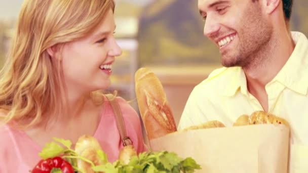 Casal sorrindo para a câmera com produtos comprados — Vídeo de Stock