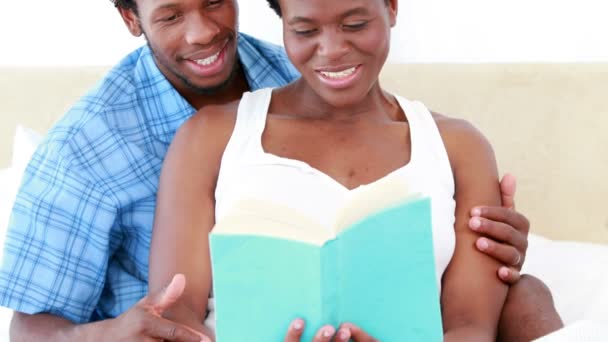 Mulher grávida e seu marido lendo um livro — Vídeo de Stock