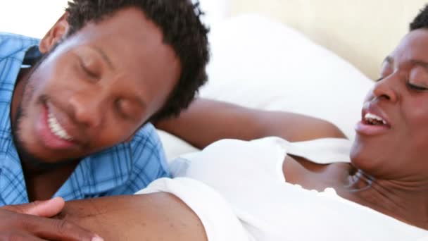Щасливий чоловік слухає свою вагітну дружину живіт — стокове відео