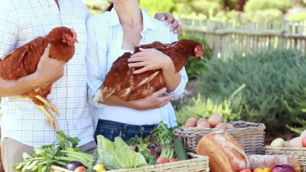 Pareja campesina sonriente sosteniendo pollos — Vídeo de stock