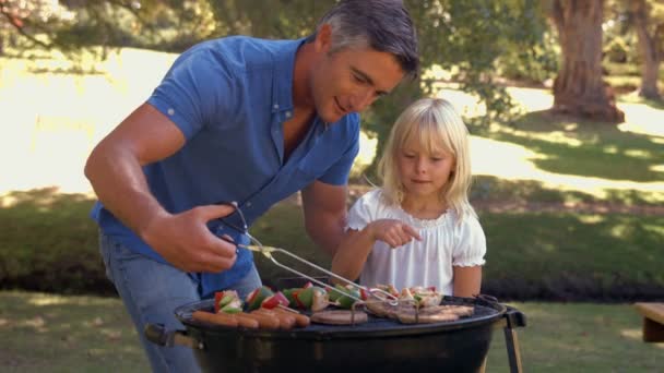 Отец устраивает барбекю со своей дочерью — стоковое видео
