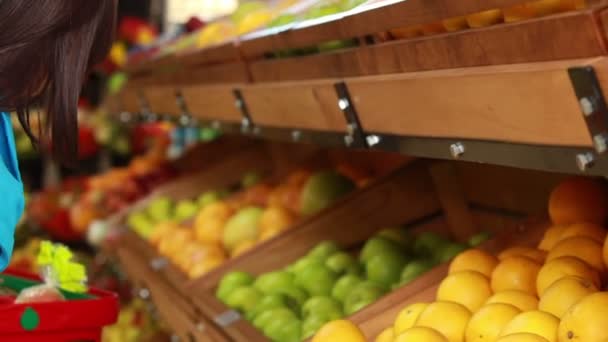 Brunette mettant des citrons dans le panier — Video