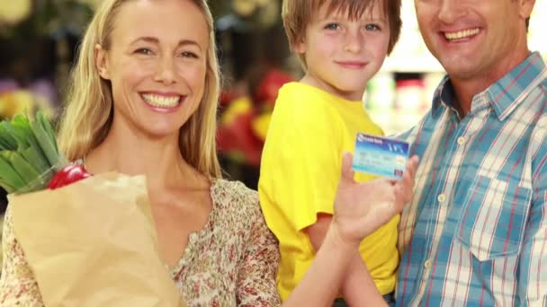 Família com saco de papel mostrando cartão de crédito — Vídeo de Stock