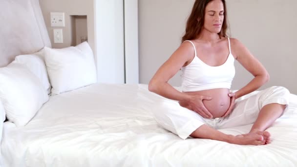 Gravid kvinna mediterar på sängen — Stockvideo