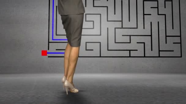 Businesswoman looking at grey wall with maze — Stock Video