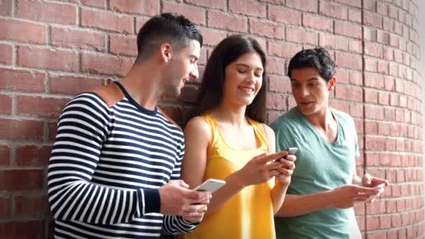 Estudantes universitários usando seus telefones em uma linha — Vídeo de Stock