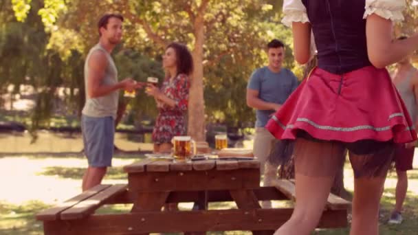Официантка приносит пиво в парк — стоковое видео
