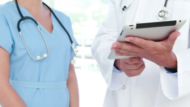 Lekarz i pielęgniarka przy użyciu komputera typu tablet — Wideo stockowe