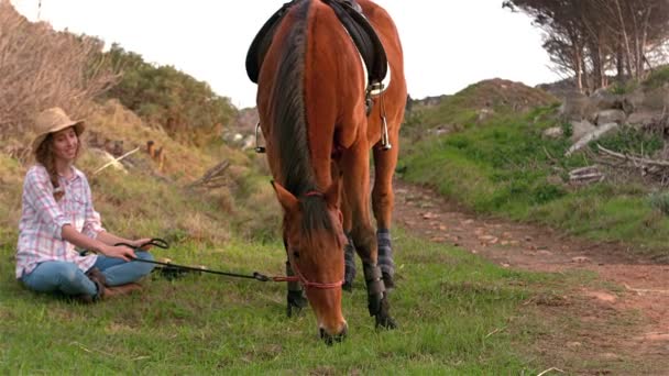 Femme assise à côté du cheval — Video