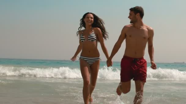 Paar läuft händchenhaltend aus dem Wasser — Stockvideo