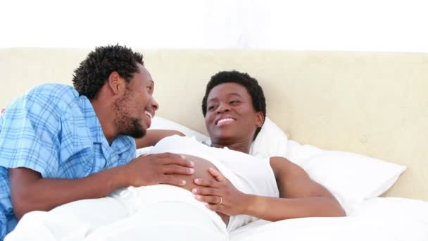 Couple enceinte discutant ensemble sur le lit — Video