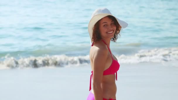 Brunette glimlachen op de camera op het strand — Stockvideo