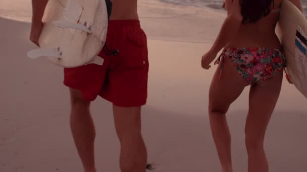 Pareja corriendo junto al mar con tablas de surf — Vídeos de Stock