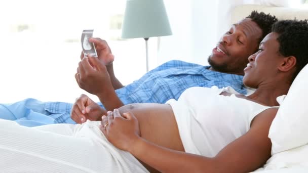 Happy pregnant couple looking at an ultrasound — Stock Video