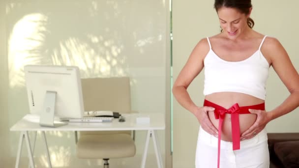 Беременная женщина с лентой на шишке — стоковое видео