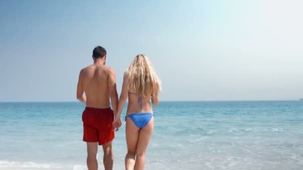 Nettes Paar geht am Strand spazieren — Stockvideo