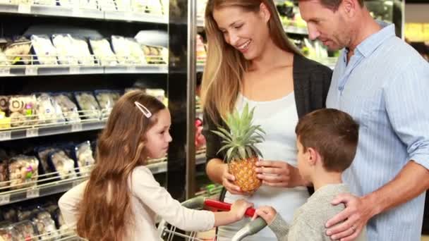 Familia recogiendo piña en el supermercado — Vídeo de stock