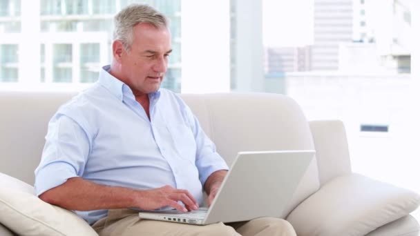 Lachende zakenman die op zijn laptop werkt — Stockvideo