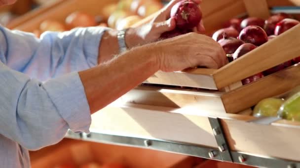 Mann pflückt Zwiebeln im Supermarkt — Stockvideo