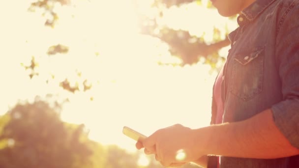 Hombre usando su teléfono inteligente en el parque — Vídeo de stock