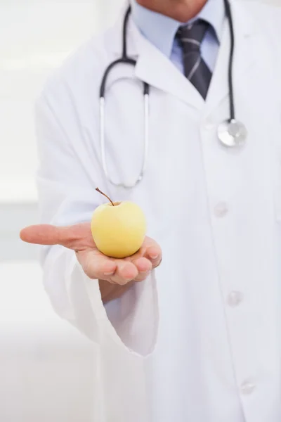 Médico segurando maçã na mão — Fotografia de Stock