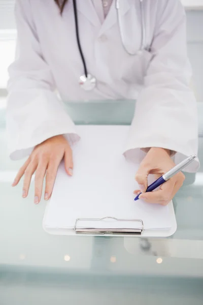 Médico escrevendo na área de transferência — Fotografia de Stock