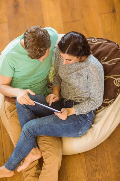 Pareja usando tableta pc en bolsa de frijoles —  Fotos de Stock