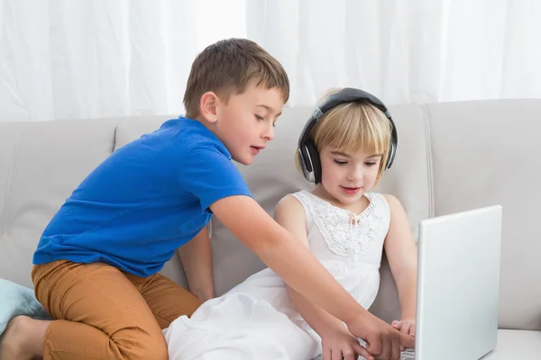 Irmãos usando fone de ouvido e tablet — Fotografia de Stock