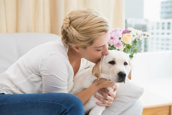Donna coccole con cucciolo sul divano — Foto Stock