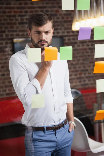 Empresário olhando para notas pegajosas — Fotografia de Stock