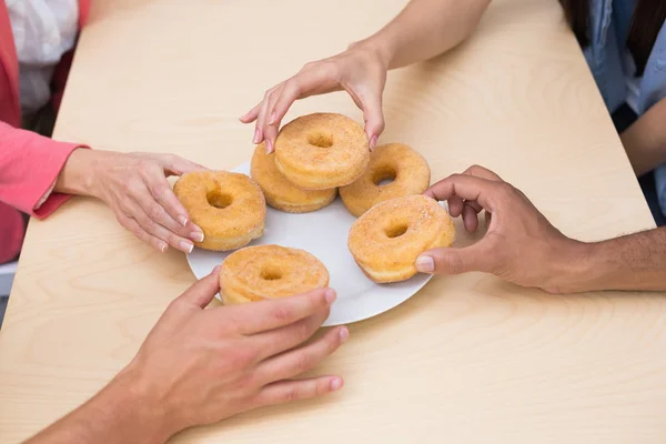 Equipe de negócios chegar para donuts — Fotografia de Stock