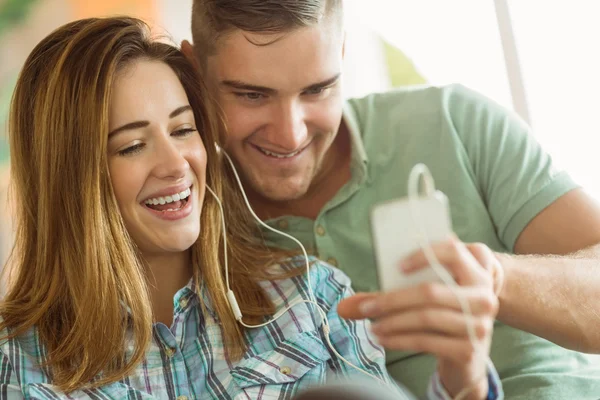 Couple relaxing on couch with smartphone — Stock Photo, Image