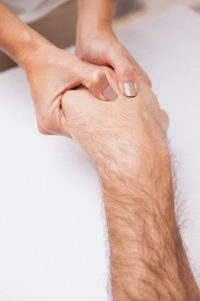 Manicurista massaggiare la mano di un cliente — Foto Stock