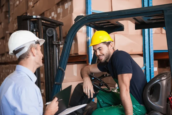 Manager talking with forklift driver — Stock Photo, Image