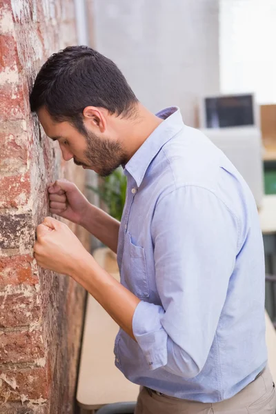 Uomo d'affari in piedi contro muro di mattoni — Foto Stock