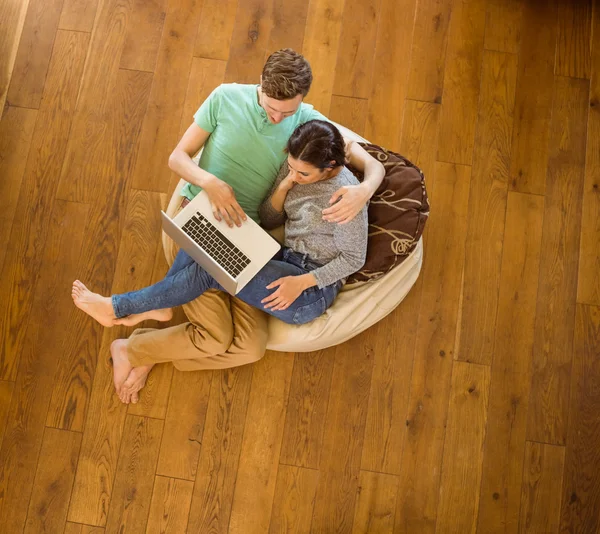 Par med laptop på beanbag — Stockfoto