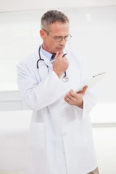 Doctor looking over medical notes — Stock Photo, Image