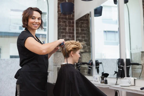 Friseur trocknet Kunden die Haare — Stockfoto