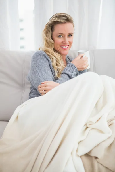 Frau mit Tasse sitzt auf Couch — Stockfoto