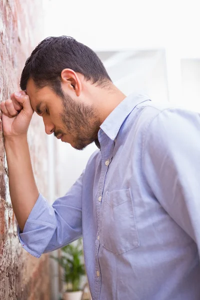 Affärsman står mot tegelvägg — Stockfoto