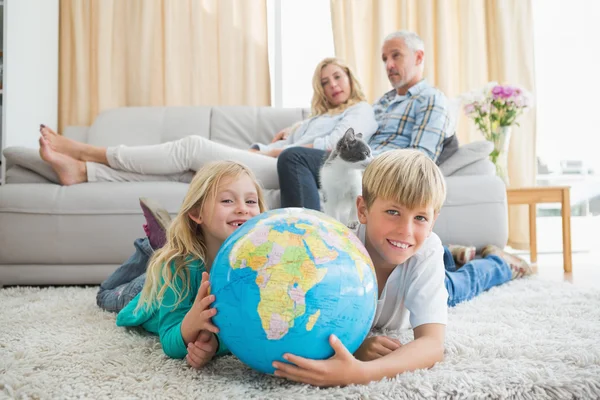 Siblings looking at globe — Stock Photo, Image