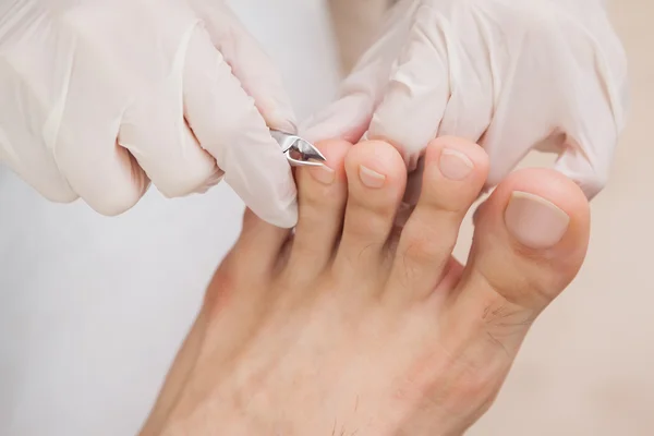 Pedicurist działa na paznokcie klientów — Zdjęcie stockowe