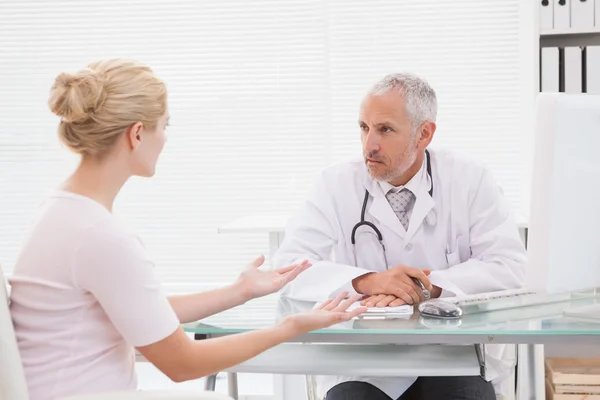 Patient consulting serious doctor — Stock Photo, Image