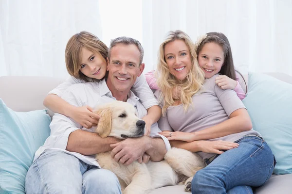 Famille se détendre ensemble sur le canapé avec chien — Photo