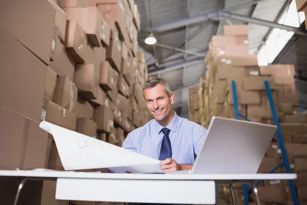 Manager met blauwdruk en laptop — Stockfoto