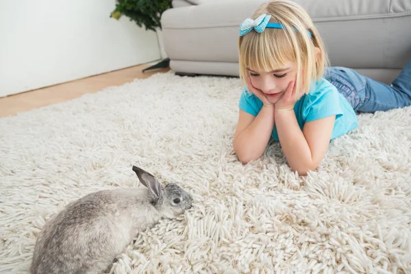 Dívka ležela na koberci s králíčkem — Stock fotografie