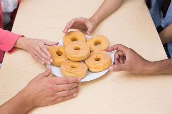 Equipe de negócios chegar para donuts — Fotografia de Stock