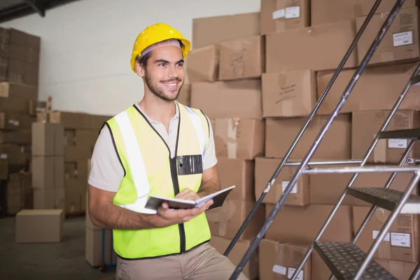 Worker with diary in warehouse — Stock Photo, Image